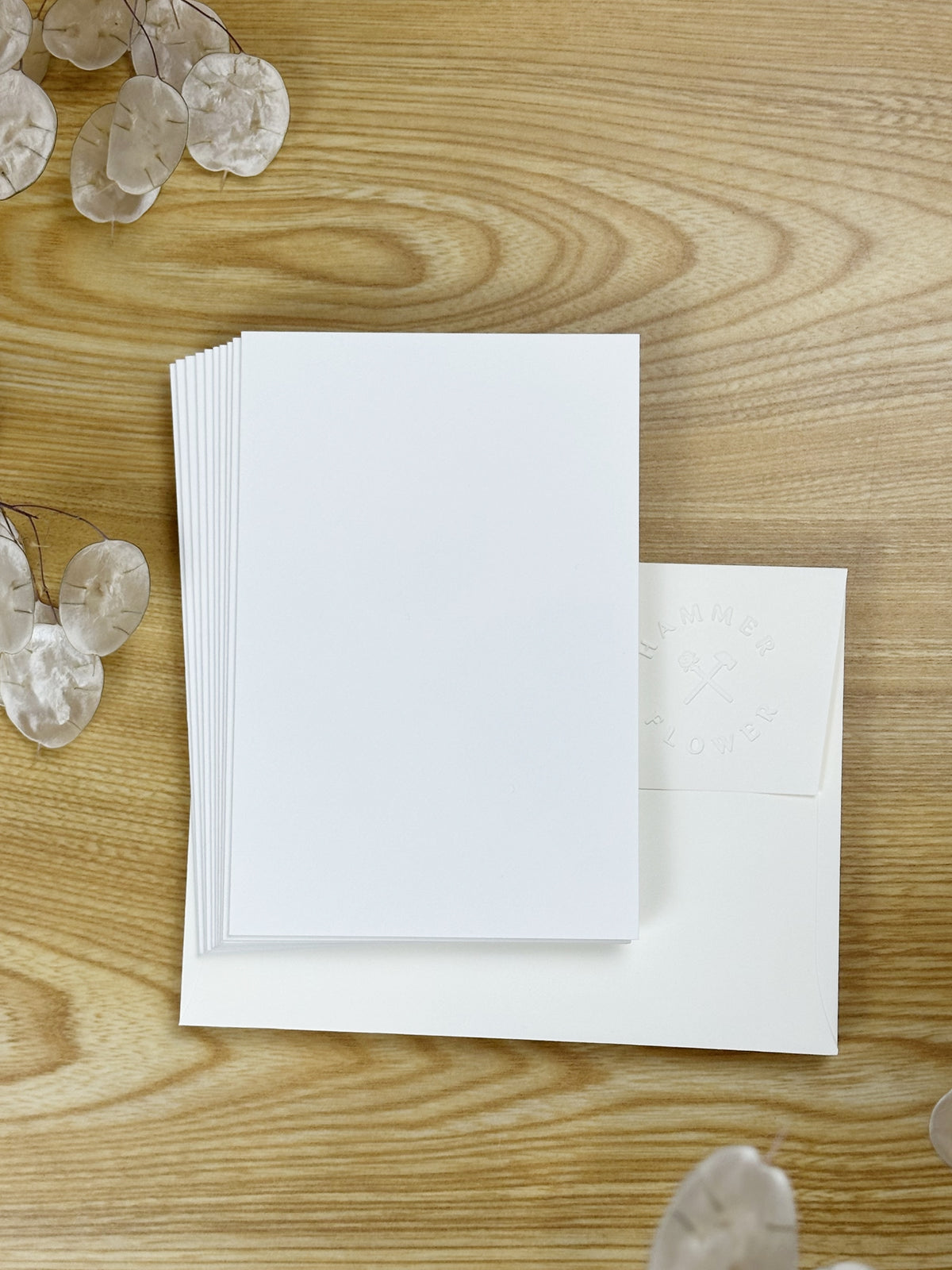 Blank watercolor greeting cards with a HammerFlower embossed envelope on a wooden table