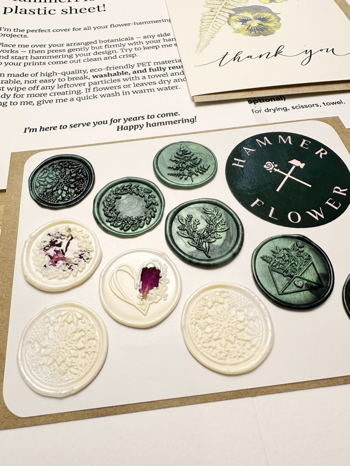 Green and ivory handmade self-adhesive wax seals with botanical and snowflake designs