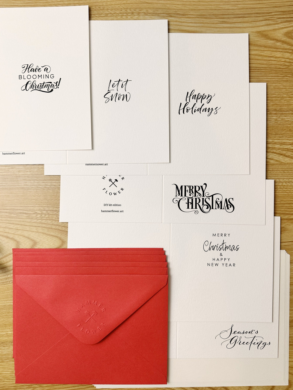 Watercolor holiday greeting cards with assorted festive lettering and red envelopes