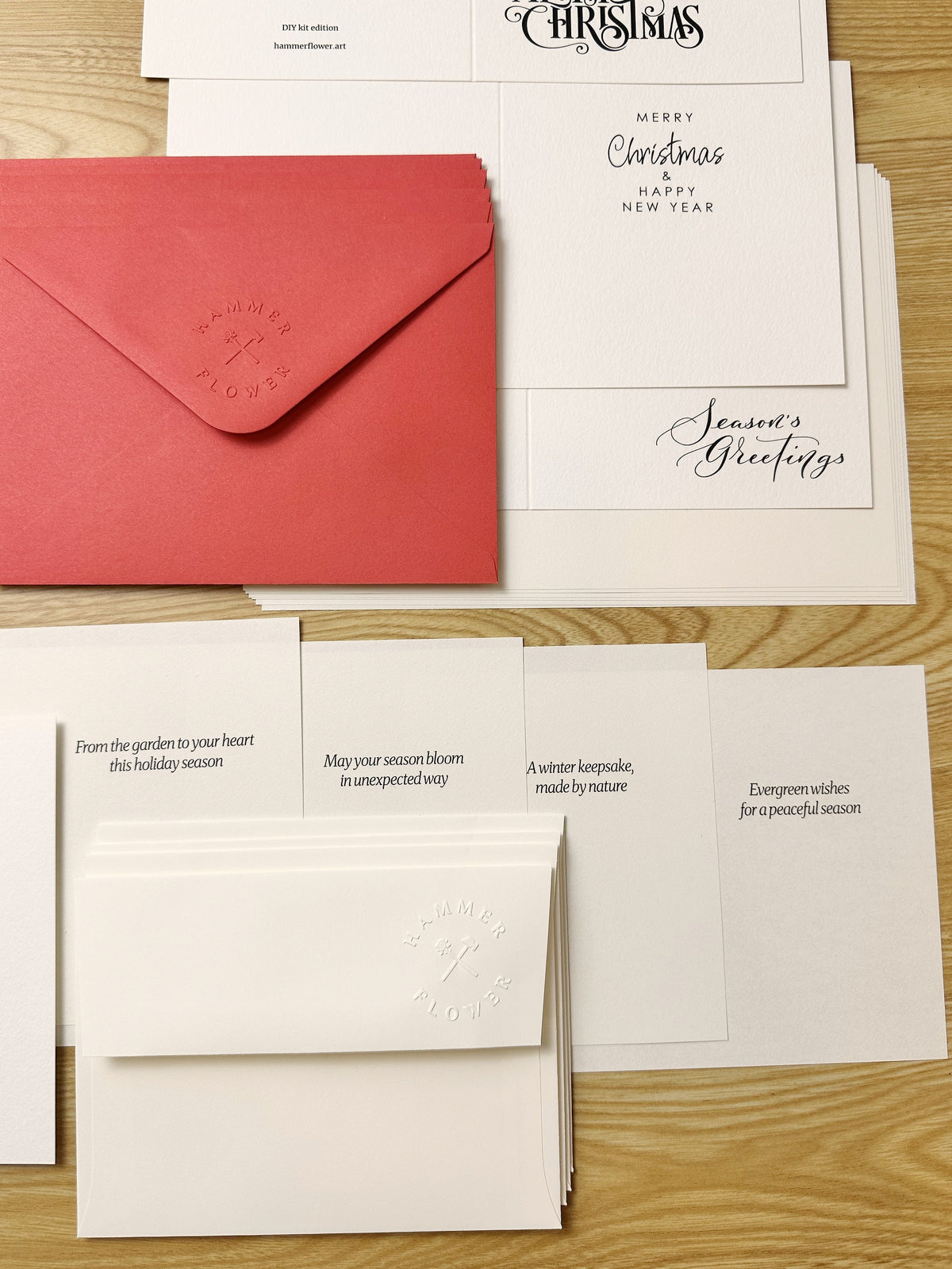 Red and warm white envelopes with holiday greeting cards and pre-printed message inserts